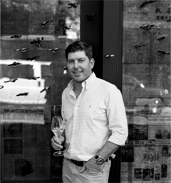 Dave Phinney, founder of Orin Swift Cellars, smiling with a glass of wine in his hand.