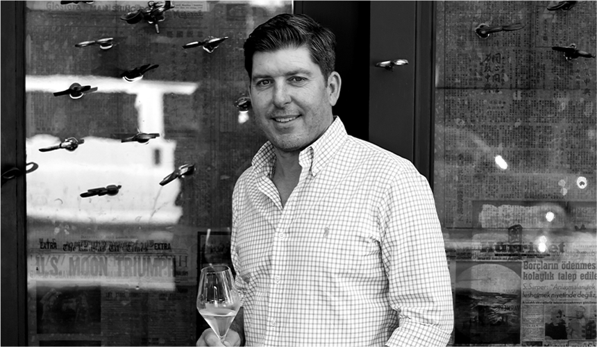 Dave Phinney, founder of Orin Swift Cellars, smiling with a glass of wine in his hand.