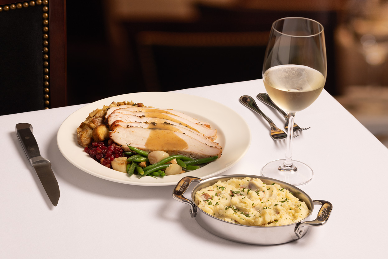 Thanksgiving dinner served with a glass of white wine. 
