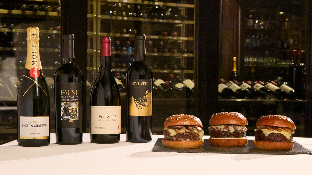 Bottles of wine next to Wagyu burgers.