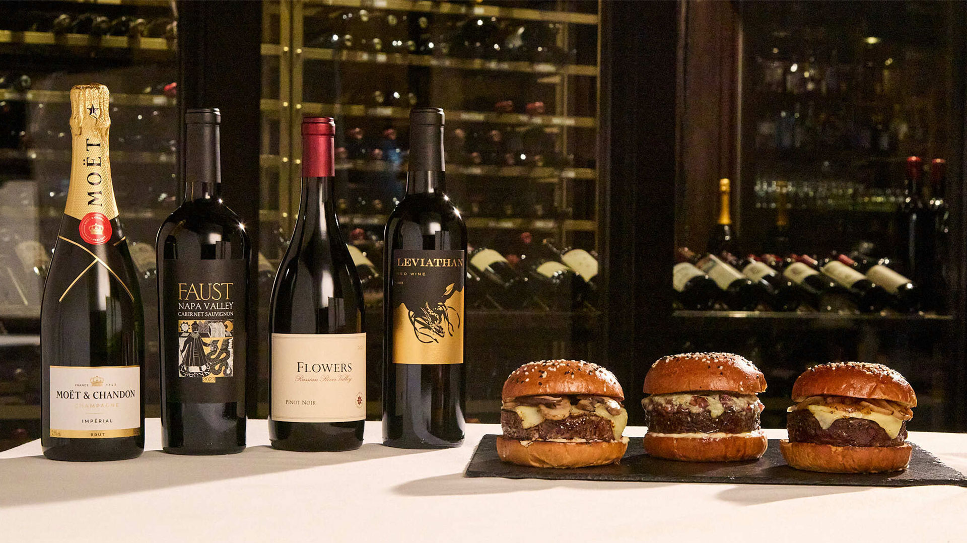 Bottles of wine next to Wagyu burgers.